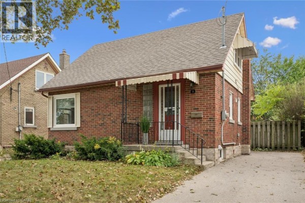 Front exterior of a red brick bungalow with a grey roof and awning. - 35 Acacia Street, Kitchener