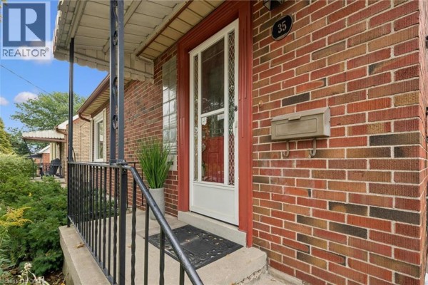 Close-up of the red brick front entrance with a white door and glass panels. - 35 Acacia Street, Kitchener