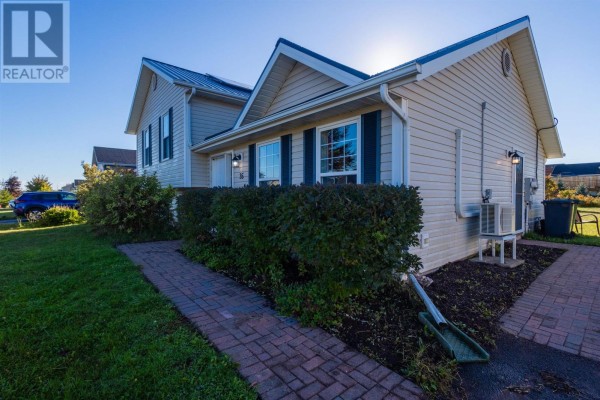 Side view of a beige house with dark shutters and a brick walkway. - 35 Barbour Circle, Charlottetown