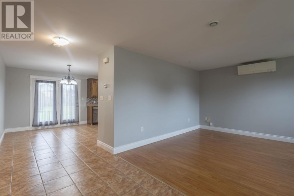 Open concept living and dining area with tiled and wood floors, grey walls. - 35 Barbour Circle, Charlottetown