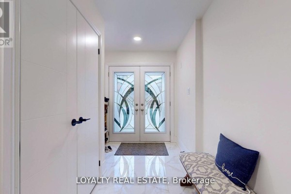 Bright entryway with double glass doors, decorative tile flooring, and a welcome mat. - 35 Bavin Street, Clarington