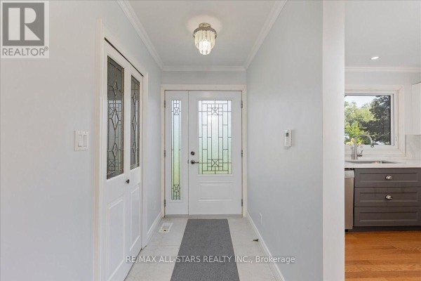 Interior view of the entryway with a glass-paned front door and adjacent closet. - 35 Lake Drive E, Georgina