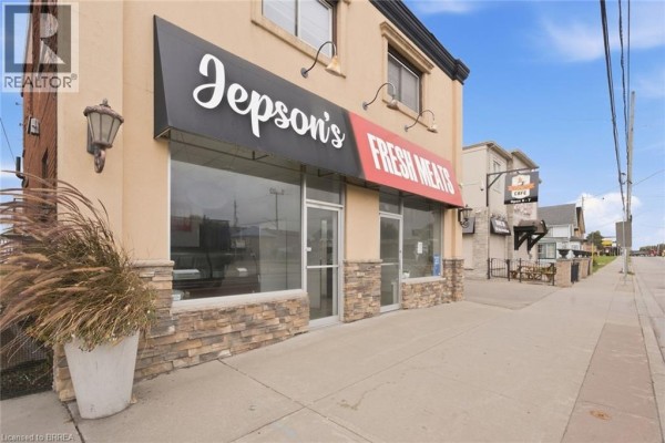 Street view of storefront with large glass windows, black awning, and stone base. - 35 Main Street N, Hagersville