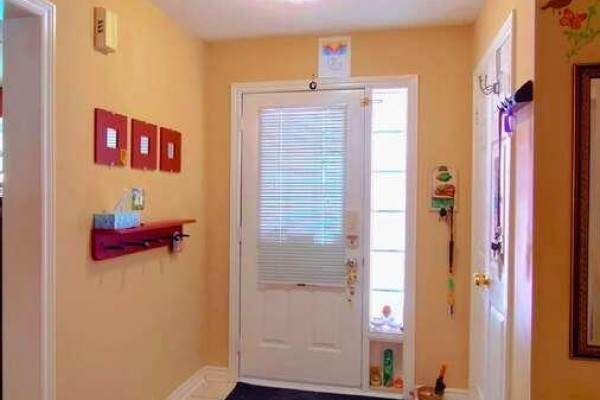 Second-floor hallway with beige walls, wooden railing, and multiple doors - 35 Raquel Street, Barrie
