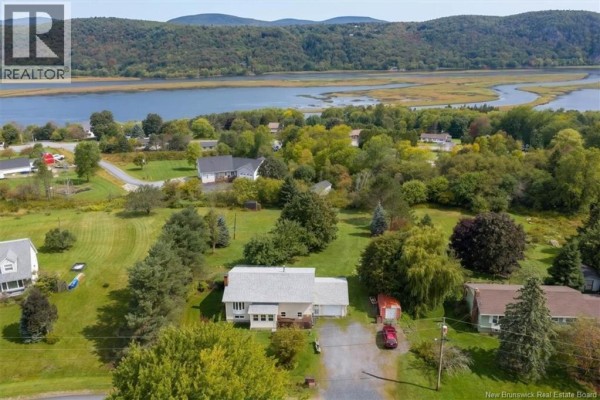 Aerial view of house with expansive green lawn and river in background. - 35 Reynar Drive, Quispamsis