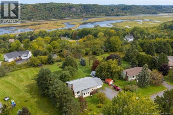 Aerial view of residential neighborhood with houses, trees, and a wide river. - 35 Reynar Drive, Quispamsis