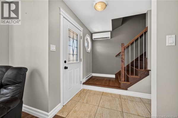 Entryway of a home with a white door, decorative glass, and a view of the staircase. - 35 Ruby Way, Moncton