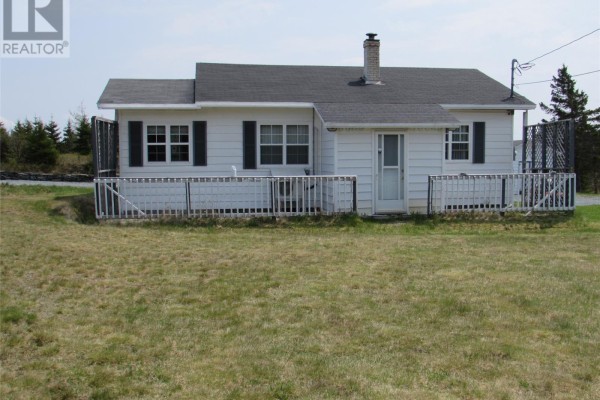 Rear view of bungalow showing white siding, a chimney, and a utility door. - 35 Ryan's Hill, Colliers