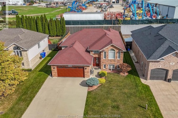 Aerial view of a brick house with a red roof and attached garage in a suburban neighborhood. - 35 Sandy Lake, Leamington