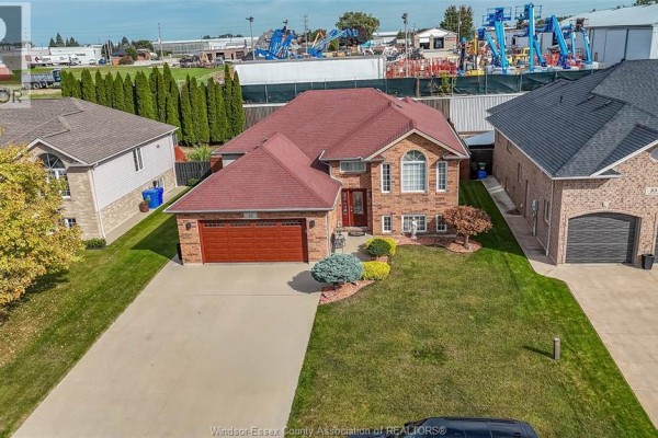 Aerial view showing the front of a brick house with a red roof and manicured lawn. - 35 Sandy Lake, Leamington