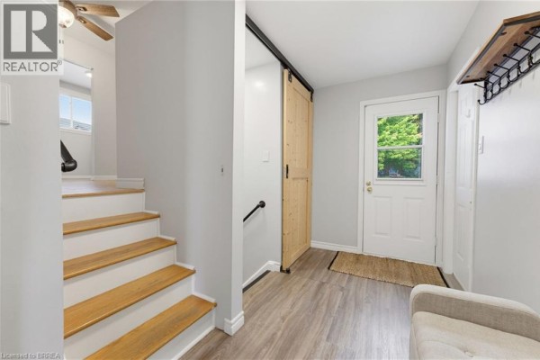 Interior view of a staircase with wood treads, a banister, and light grey walls. - 35 Scott Road, Cambridge