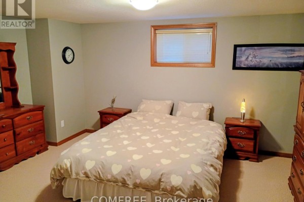 Bedroom with heart duvet, wooden furniture, clock, and window - 35 Tanya Drive Southwest Middlesex