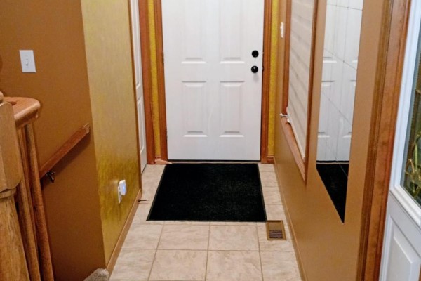 Hallway with tile floor, white door, and wooden stairs - 35 Tanya Drive Southwest Middlesex