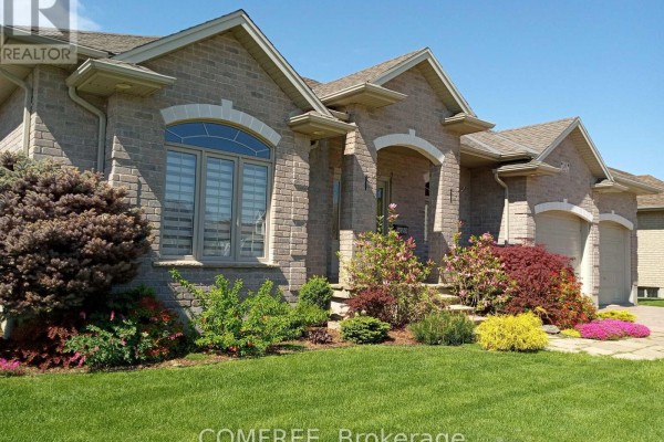 Brick home with arched entry and window, landscaped garden, and attached garage - 35 Tanya Drive Southwest Middlesex