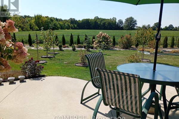 Patio furniture overlooking a green field and trees - 35 Tanya Drive Southwest Middlesex
