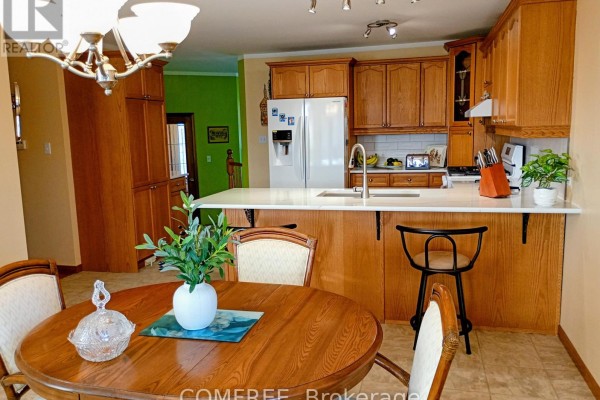 Wood cabinets, island with sink, and dining table - 35 Tanya Drive Southwest Middlesex