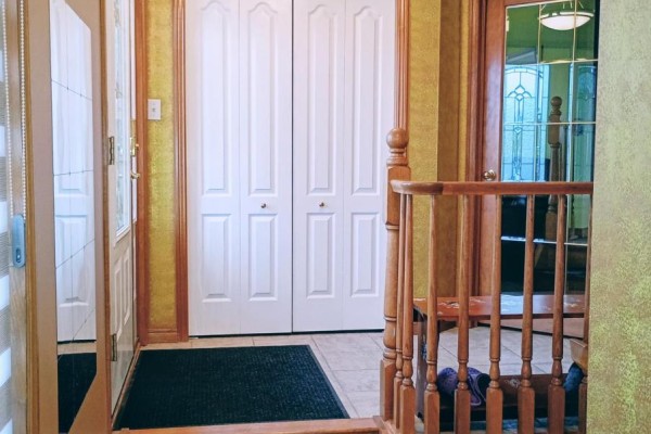 Hallway with wooden staircase and double closet doors - 35 Tanya Drive Southwest Middlesex