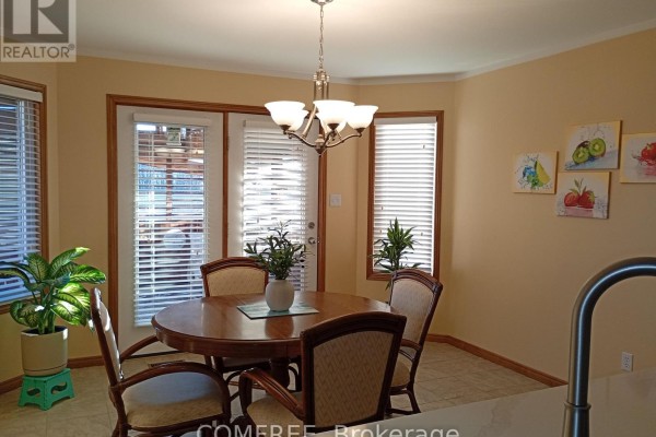 Round dining table and chairs with fruit art and windows - 35 Tanya Drive Southwest Middlesex