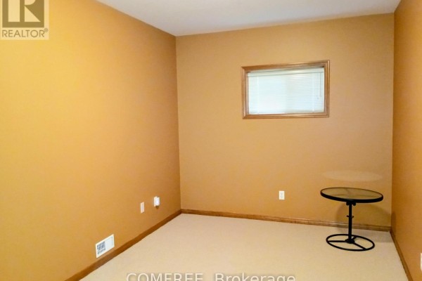 Tan walls and beige carpet in a room with a small window and side table - 35 Tanya Drive Southwest Middlesex