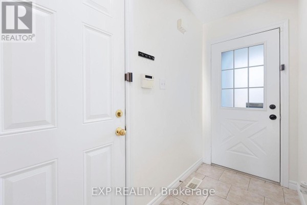 Interior view of a bright white entryway with two doors and tiled flooring. - 35 Thames Way, Hamilton