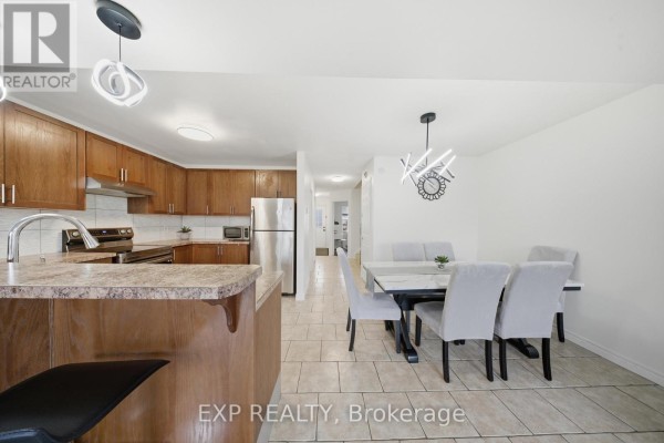 Kitchen with wooden cabinets and dining area - 35 Thames Way Hamilton