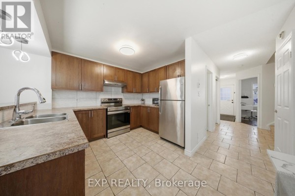 Kitchen with wood cabinets, stainless steel appliances, and tiled floor - 35 Thames Way Hamilton