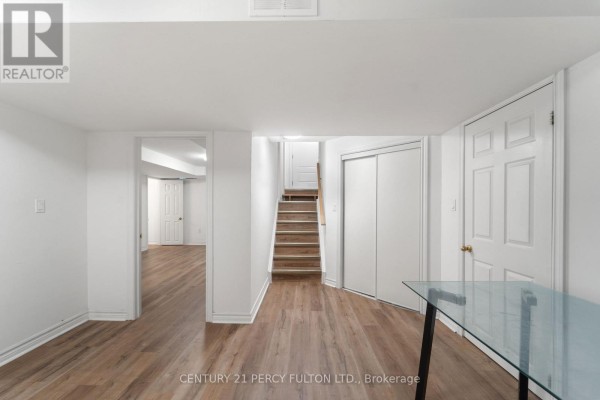 Living room with two tufted sofas, pale blue walls, and parquet flooring next to the entryway. - 35 Weldon Street, Whitby