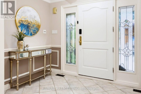 Interior entryway with a white double door, stained glass sidelights, and a console table. - 35 Yellow Pine Crescent, Vaughan