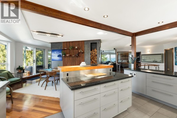 Kitchen island with granite and butcher block, overlooking dining area and living room with ocean views. - 350 Bayview Place, Lions Bay