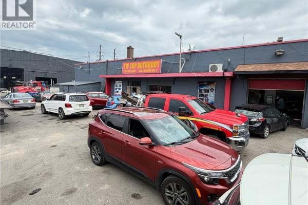 View of commercial building facade with vehicles including tow trucks and passenger cars. - 350 Sherman Avenue N, Hamilton