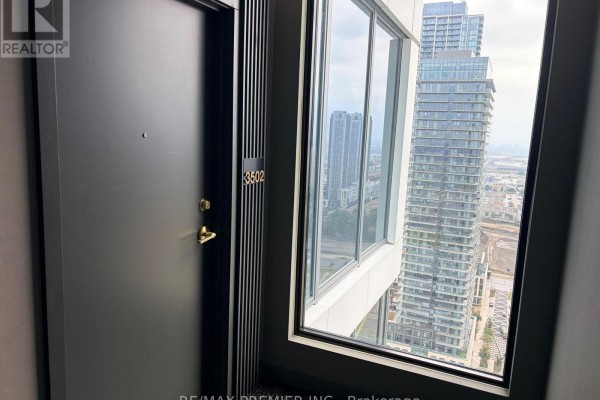 Apartment door numbered 3502 with a gold handle, beside a large window. - 3502 - 5 Buttermill Avenue, Vaughan