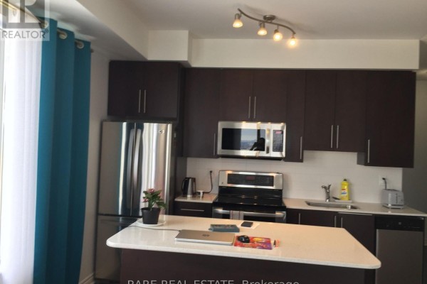Modern kitchen with dark brown cabinets, stainless steel appliances, and a white island. - 3505 - 385 Prince Of Wales Drive, Mississauga