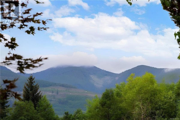 Panoramic view of mountains and forested hills under a partly cloudy sky. - 3505 Harris Cres, Qualicum Beach