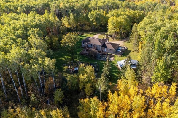 Aerial view of a house nestled in a dense forest during autumn. - 35091 Gueret 44e Road, La Broquerie
