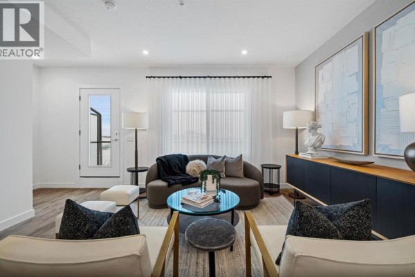 Living room with modern furniture, including a curved sofa, glass coffee table, and abstract wall art. - 351, 141 Prince Court, Rural Rocky View County