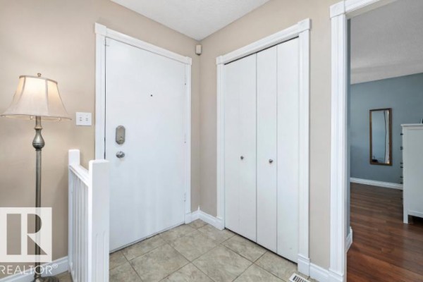 Interior view of an entryway with beige tiled floor, white doors, and a closet. - 3511 73 St Nw, Edmonton