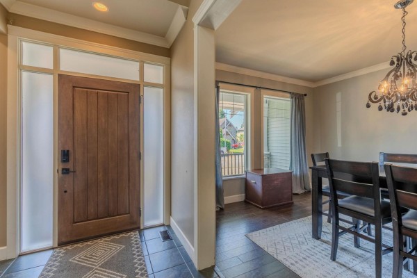 View from entryway into dining room with dark wood table and chandelier. - 35159 Mcewen Avenue, Mission