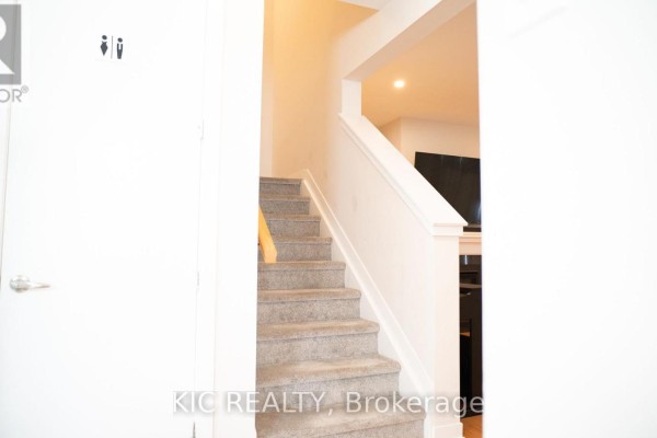 Interior view looking up a carpeted staircase with a wooden handrail and white walls. - 352 Appalachian Circle, Ottawa