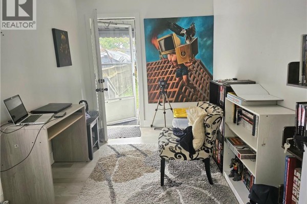 Office space with a desk, chair, and bookshelves, featuring a door leading to the backyard. - 352 Weir Street N, Hamilton