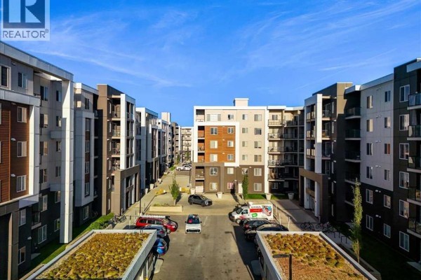 Exterior view of modern apartment buildings with parking lot and blue sky. - 3520, 4641 128 Avenue Ne, Calgary