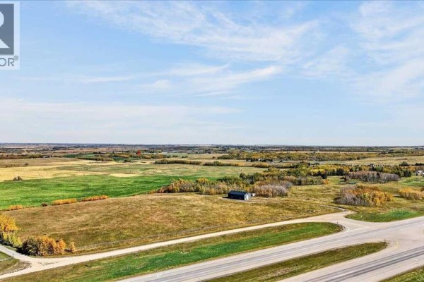 Expansive view of rural land with fields, trees, and a highway in the foreground. - 35254 Highway 1a, Rural Rocky View County