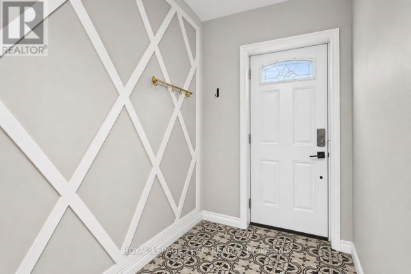 Entranceway with grey walls, white lattice design, white door with glass, and patterned tile floor. - 353 Arlington Avenue, Ottawa