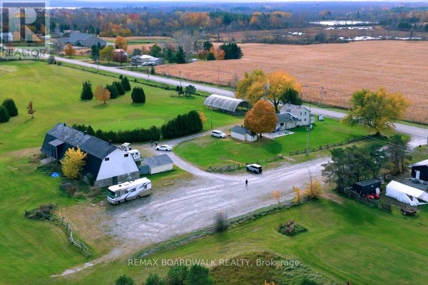 Aerial view of a farm property with barns, outbuildings, and vehicles. - 353 County Rd 5 Road, Athens