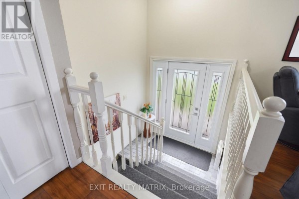 View from the top of the stairs looking down at the front entrance with white paneled doors. - 353 Nelson Street E, Hawkesbury