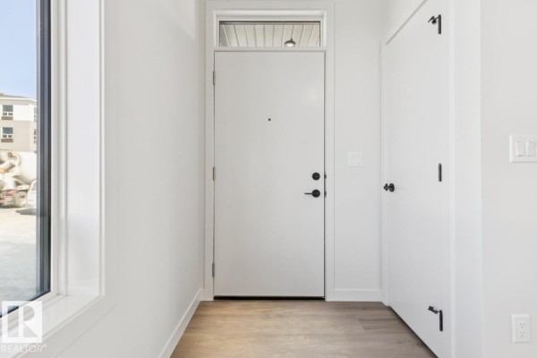 Interior view of a front entryway with a white door, light wood-look flooring, and white walls. - 353 Rankin Dr, St  Albert