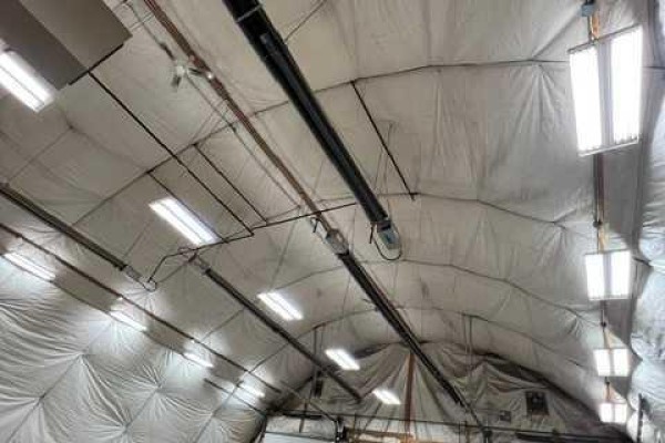 View of the vaulted ceiling inside a Quonset building with white fabric walls and fluorescent lights. - 3531 37 Avenue, Whitecourt