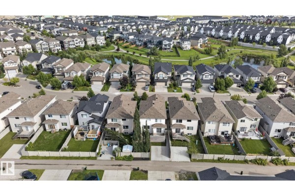 Aerial view of a suburban neighborhood with rows of houses and a small pond. - 3536 Claxton Cr Sw Sw, Edmonton