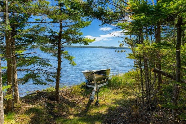 Aerial view of a small boat on a trailer at the edge of a dark, wide river. - 3539 Highway 255, Black Brook