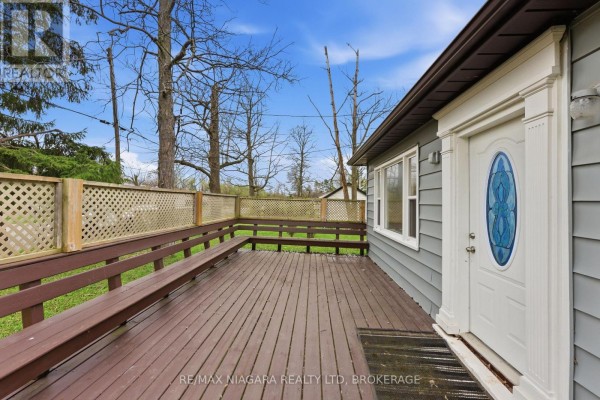 View of wooden deck with built-in bench seating and house entrance. - 355 Bernard Avenue, Fort Erie