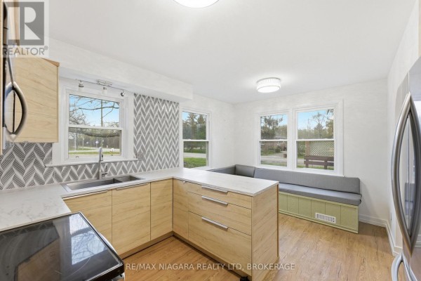 Kitchen with light wood cabinets, marble countertops, window seating, and views of the outdoors. - 355 Bernard Avenue, Fort Erie